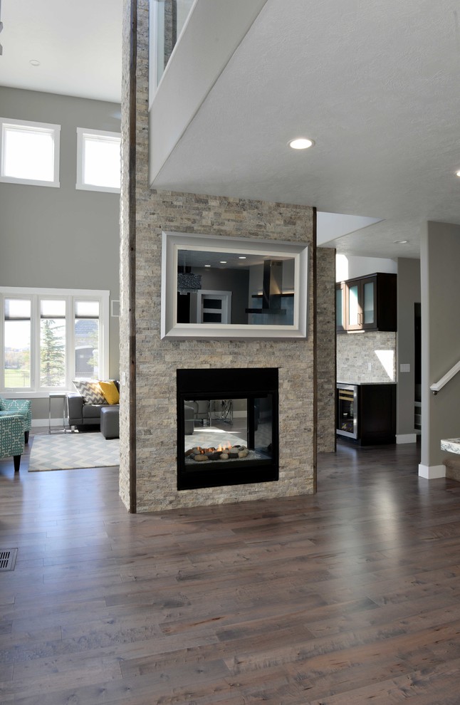 This is an example of a large transitional formal open concept living room in Other with grey walls, vinyl floors, a two-sided fireplace and a stone fireplace surround.