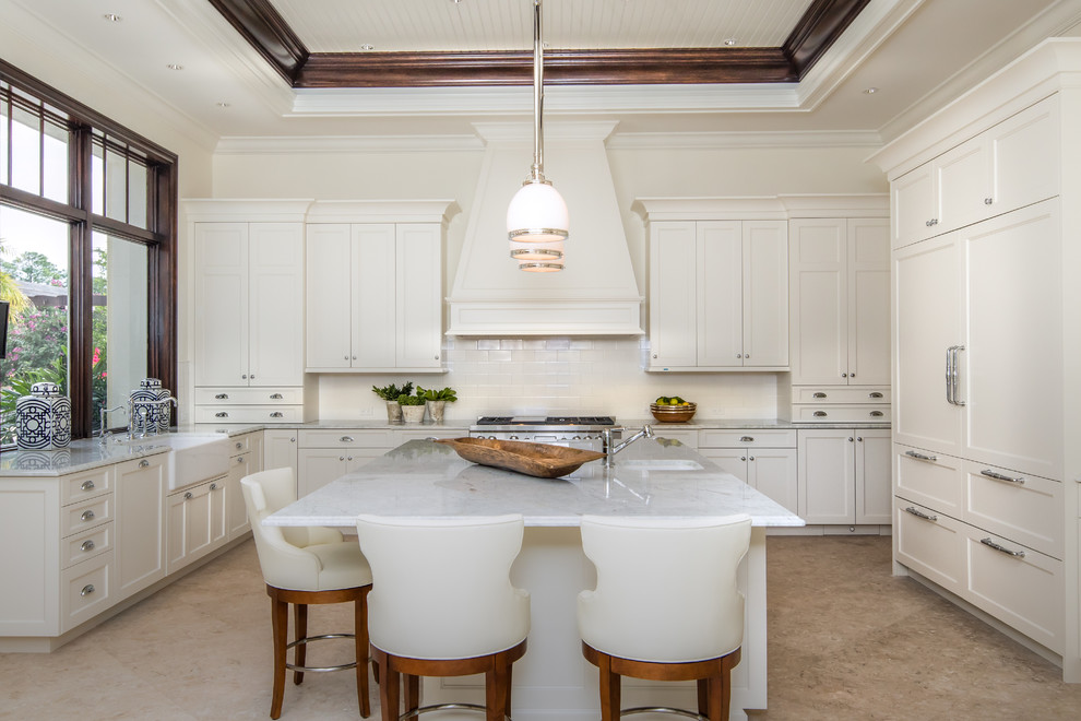Inspiration for a traditional u-shaped kitchen in Miami with a farmhouse sink, shaker cabinets, white cabinets, marble benchtops, white splashback, subway tile splashback, panelled appliances and with island.