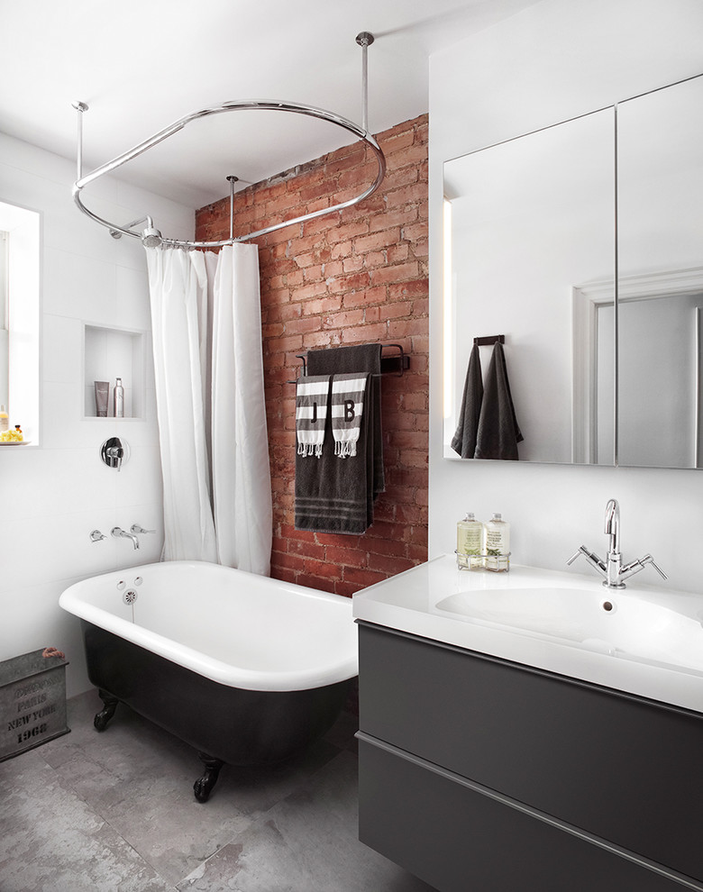 Photo of an industrial bathroom in Toronto with a console sink, flat-panel cabinets, grey cabinets, a claw-foot tub, a shower/bathtub combo, white tile and white walls.