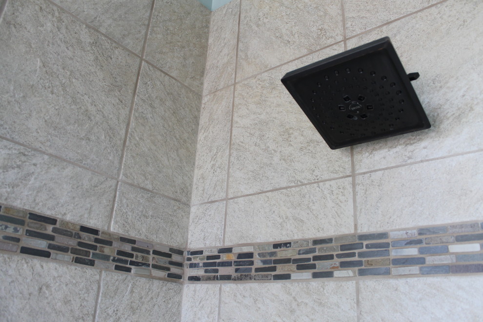 Example of a mid-sized transitional master beige tile and porcelain tile porcelain tile and brown floor walk-in shower design in Phoenix with flat-panel cabinets, black cabinets, a two-piece toilet, blue walls, an undermount sink and quartz countertops