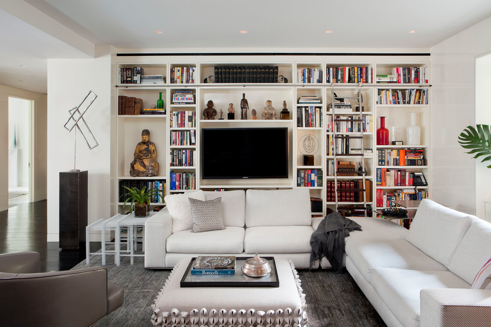 This is an example of a large contemporary open concept family room in New York with white walls, dark hardwood floors and a built-in media wall.
