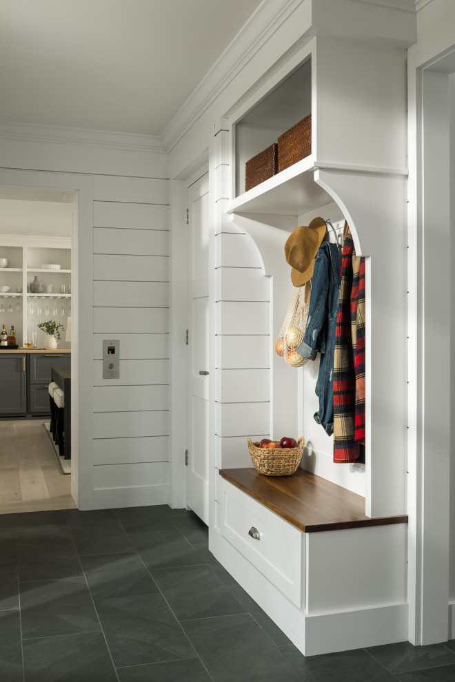 Design ideas for a beach style mudroom in Burlington with white walls and porcelain floors.