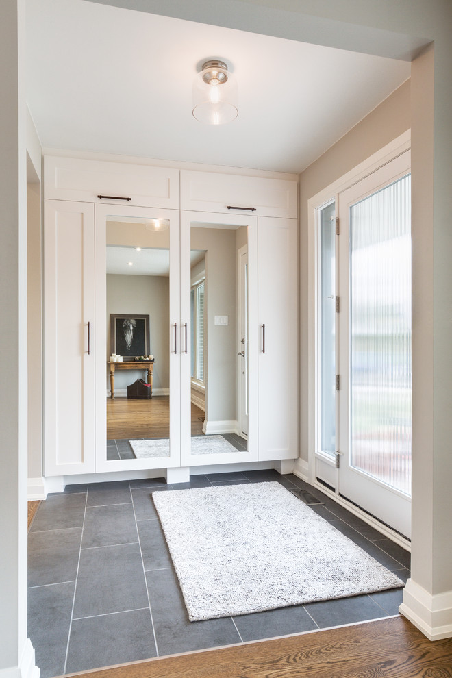 Mid-sized transitional foyer in Other with grey walls, a single front door, a glass front door and slate floors.