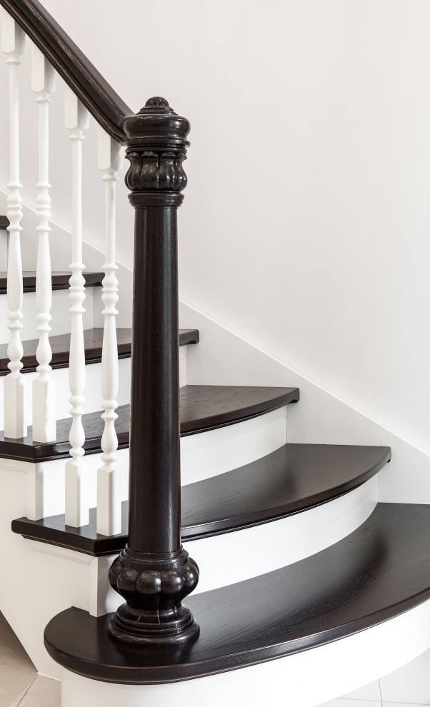 Photo of a classic wood curved wood railing staircase in London with wood risers.