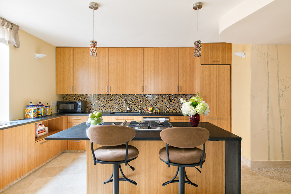 This is an example of a mid-sized contemporary l-shaped separate kitchen in New York with an undermount sink, flat-panel cabinets, medium wood cabinets, multi-coloured splashback, mosaic tile splashback, with island, stainless steel appliances and travertine floors.