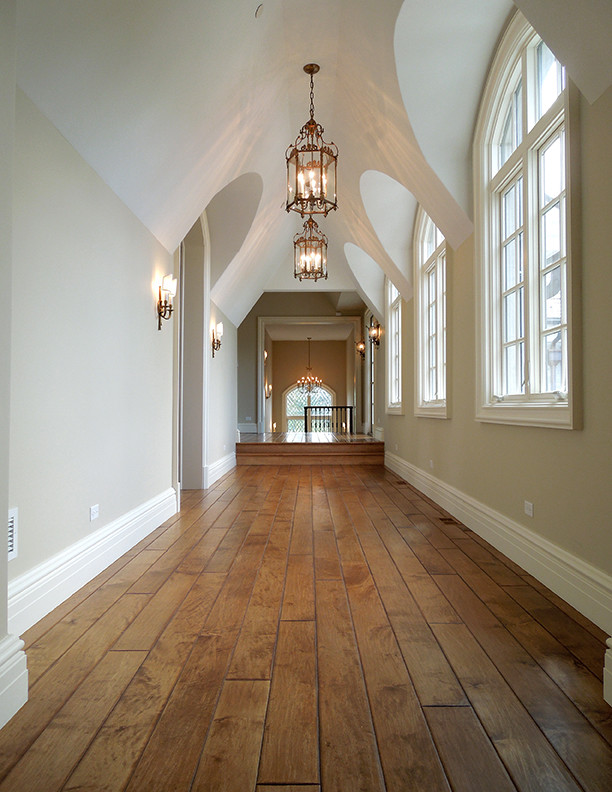 Example of a large ornate medium tone wood floor, brown floor and vaulted ceiling hallway design in Chicago