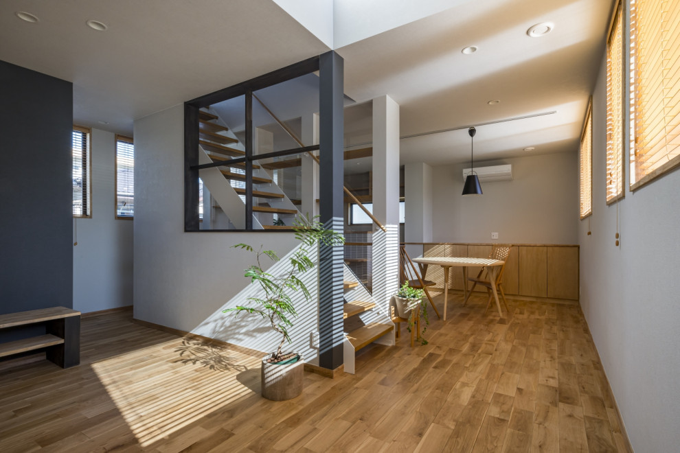 Skandinavisches Wohnzimmer mit weißer Wandfarbe, hellem Holzboden, beigem Boden und Tapetenwänden in Sonstige