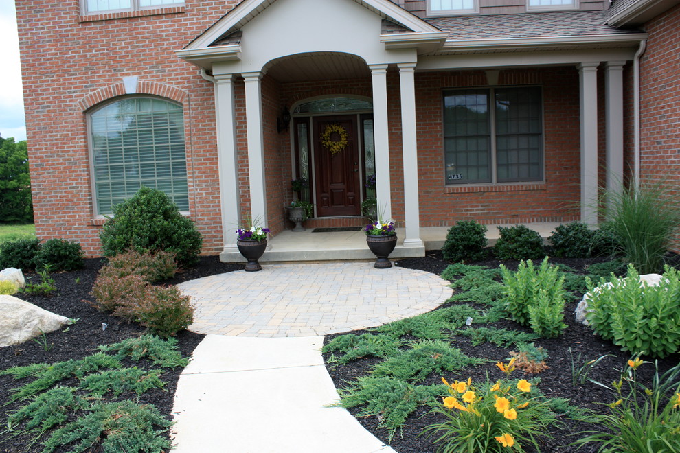 Photo of a large traditional front yard garden in Philadelphia with a container garden and brick pavers.