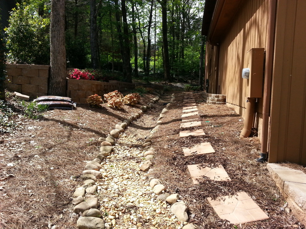 This is an example of a mid-sized rustic shade side yard concrete paver retaining wall landscape for spring.