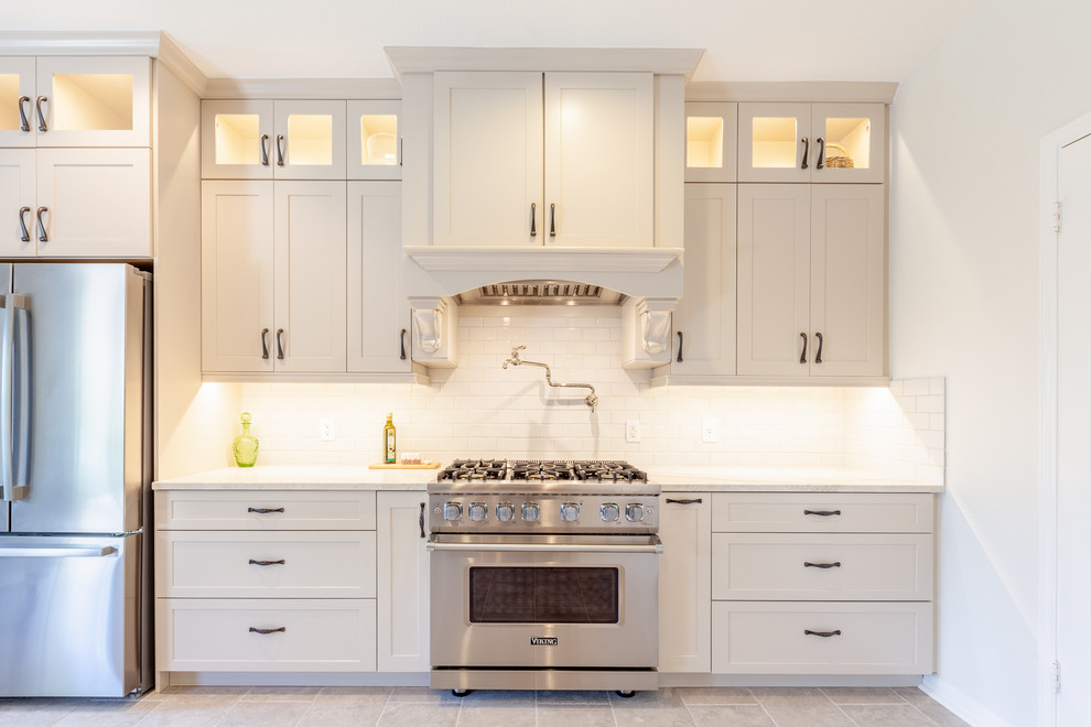 Eat-in kitchen - large transitional galley beige floor eat-in kitchen idea in Austin with an undermount sink, shaker cabinets, beige cabinets, marble countertops, white backsplash, subway tile backsplash, stainless steel appliances, two islands and white countertops