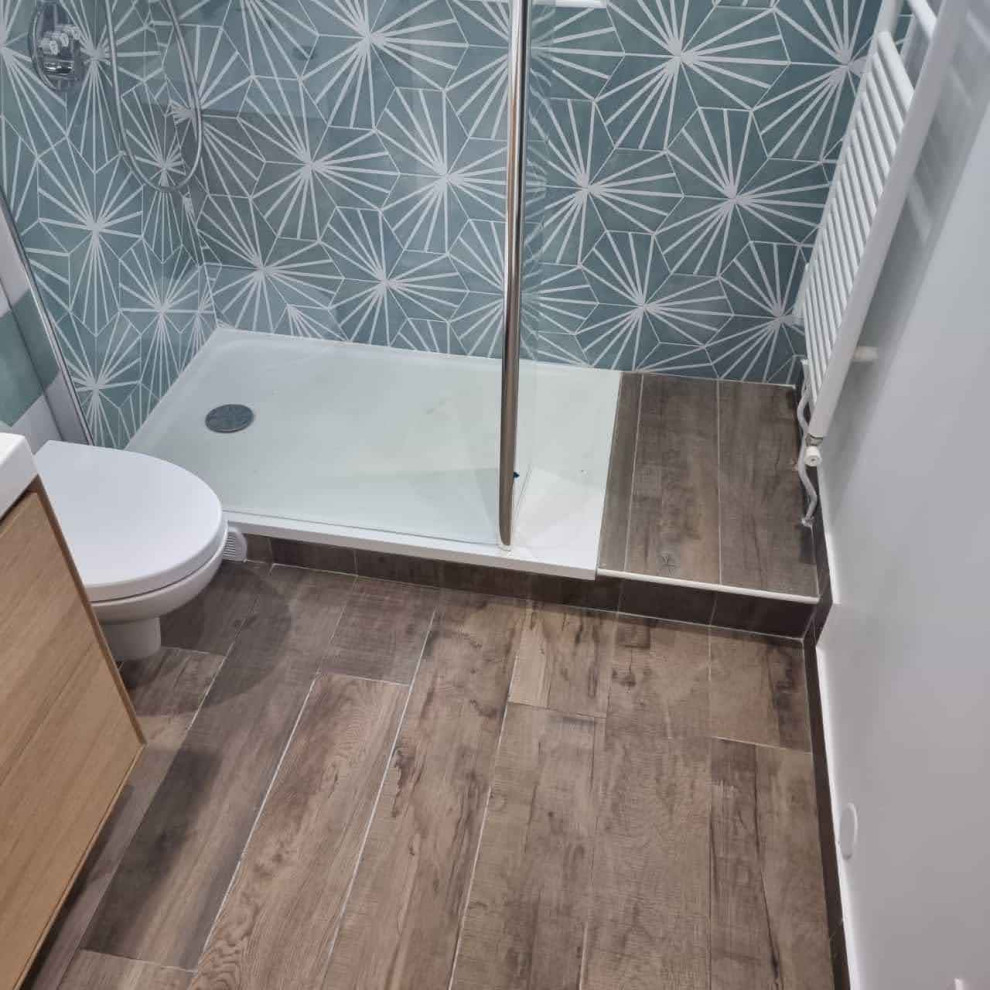 Cette image montre une petite salle de bain design en bois clair avec WC suspendus, un carrelage vert, un plan de toilette en carrelage et meuble-lavabo suspendu.