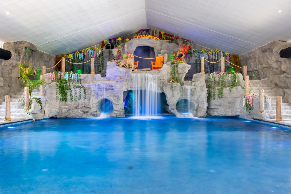 Cette photo montre une grande piscine intérieure montagne rectangle avec un toboggan et une terrasse en bois.