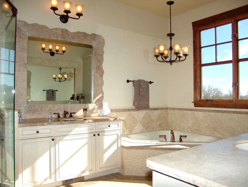 Example of a mid-sized transitional master beige tile and stone slab travertine floor corner bathtub design in Denver with recessed-panel cabinets, medium tone wood cabinets, beige walls, an undermount sink and soapstone countertops