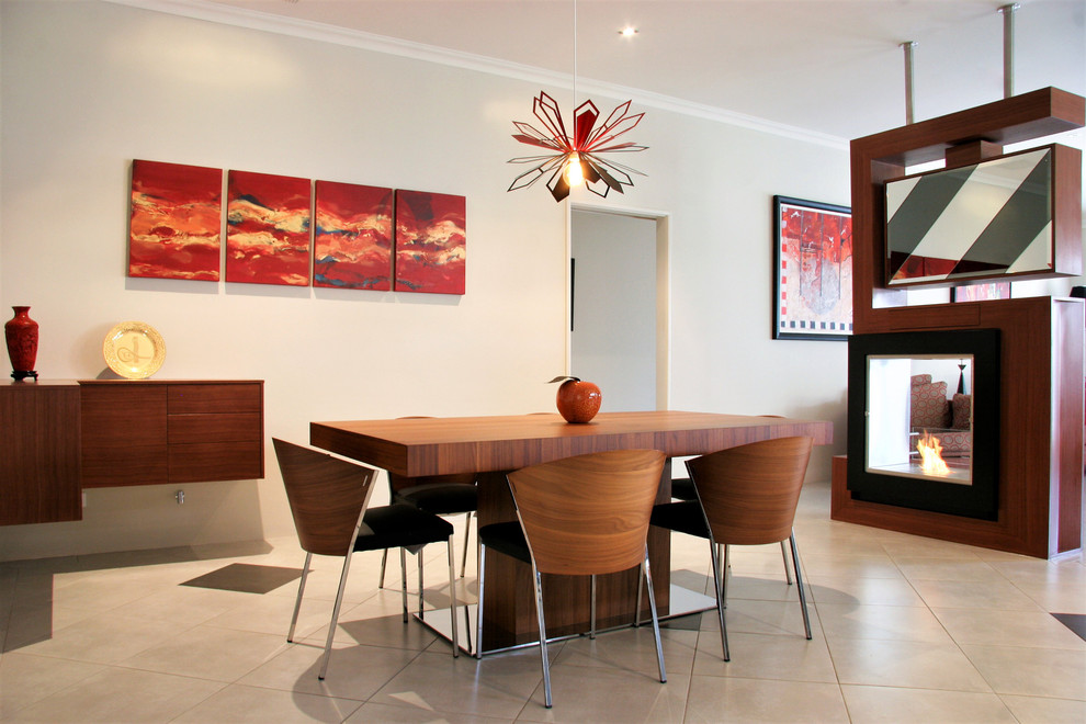 Mid-sized industrial open plan dining in Perth with white walls, ceramic floors, a two-sided fireplace, a wood fireplace surround and white floor.