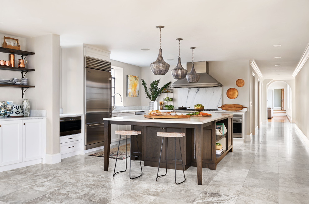 Eat-in kitchen - large mediterranean l-shaped gray floor eat-in kitchen idea in Portland with an undermount sink, recessed-panel cabinets, dark wood cabinets, marble countertops, white backsplash, marble backsplash, stainless steel appliances, an island and white countertops