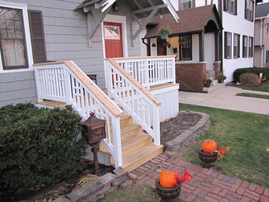 This is an example of a mid-sized traditional front yard verandah in Chicago with decking and an awning.