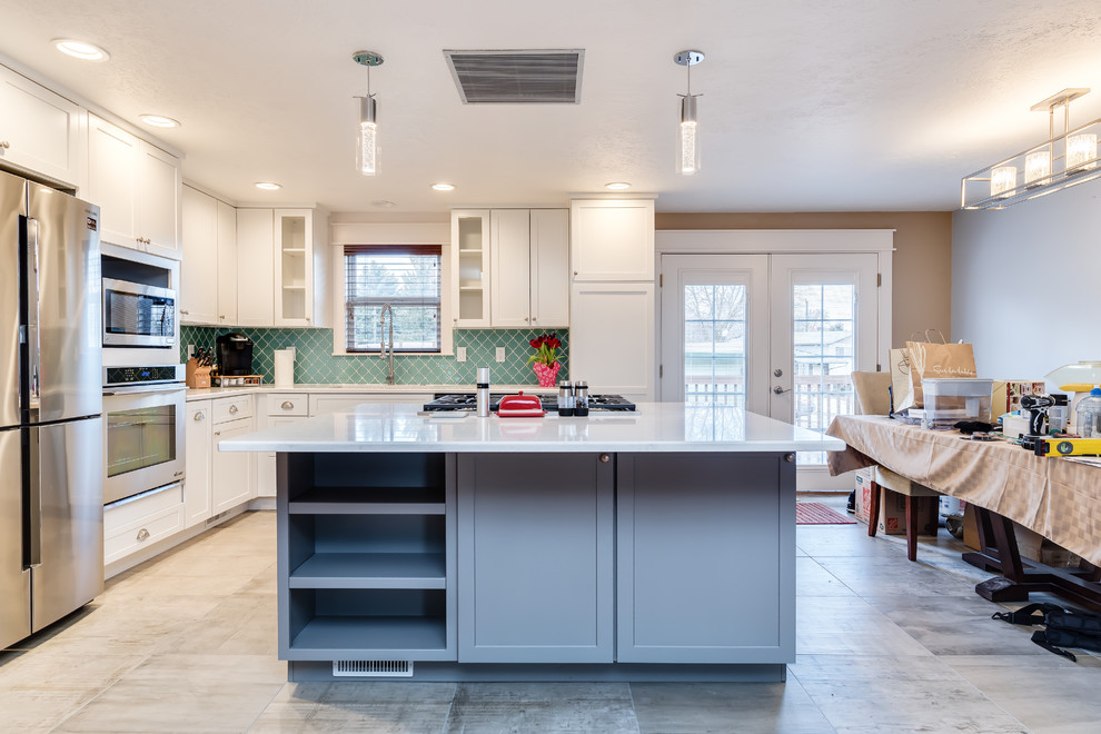 Inspiration for a small transitional l-shaped porcelain tile and gray floor eat-in kitchen remodel in Boise with a single-bowl sink, shaker cabinets, white cabinets, quartz countertops, blue backsplash, glass tile backsplash, stainless steel appliances and an island
