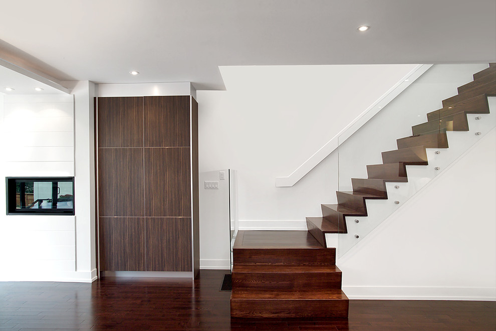 Inspiration for a modern wood staircase in Toronto with wood risers and glass railing.