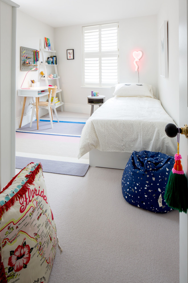 Photo of a mid-sized contemporary kids' bedroom for kids 4-10 years old and girls in London with white walls, carpet and beige floor.