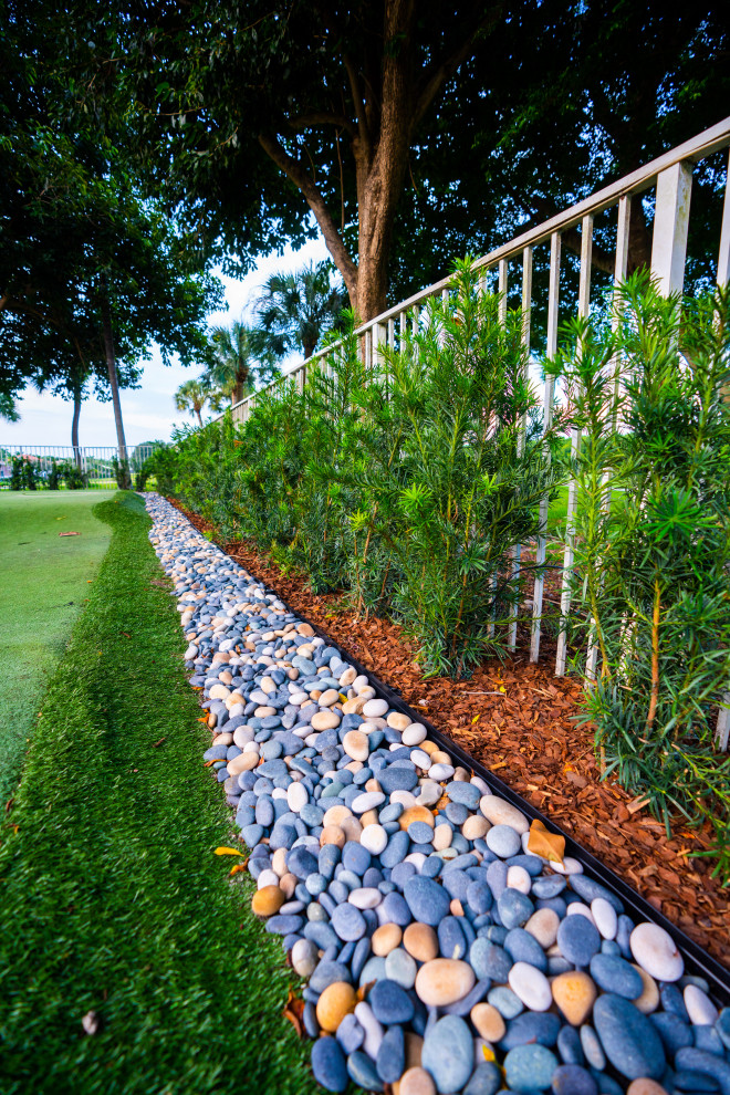 Inspiration for a large transitional rock and full sun river rock and metal fence outdoor sport court in Miami for summer.