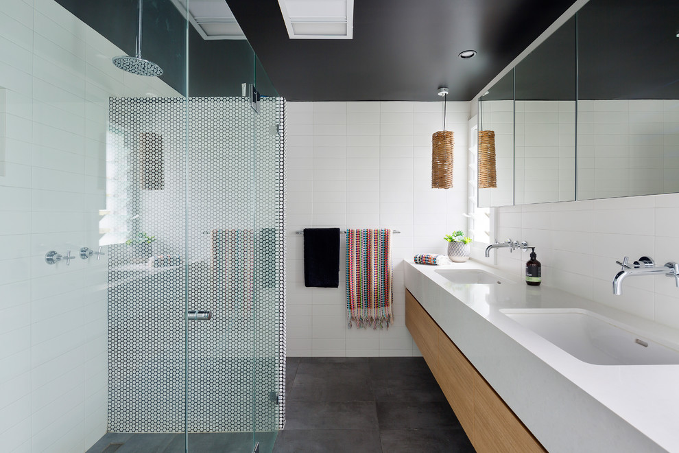 Inspiration for a contemporary master bathroom in Sydney with flat-panel cabinets, light wood cabinets, a curbless shower, white tile, white walls, an undermount sink, grey floor, a hinged shower door and white benchtops.