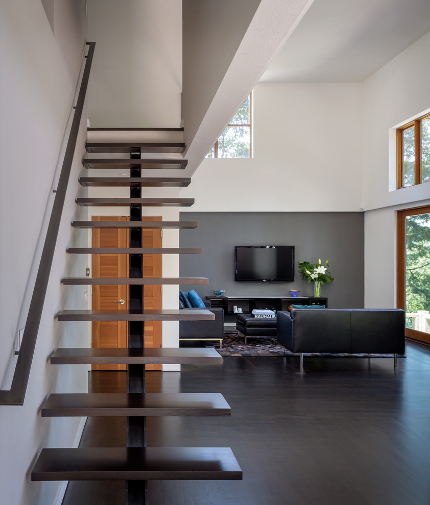 Large modern wood floating staircase in Portland with open risers and metal railing.