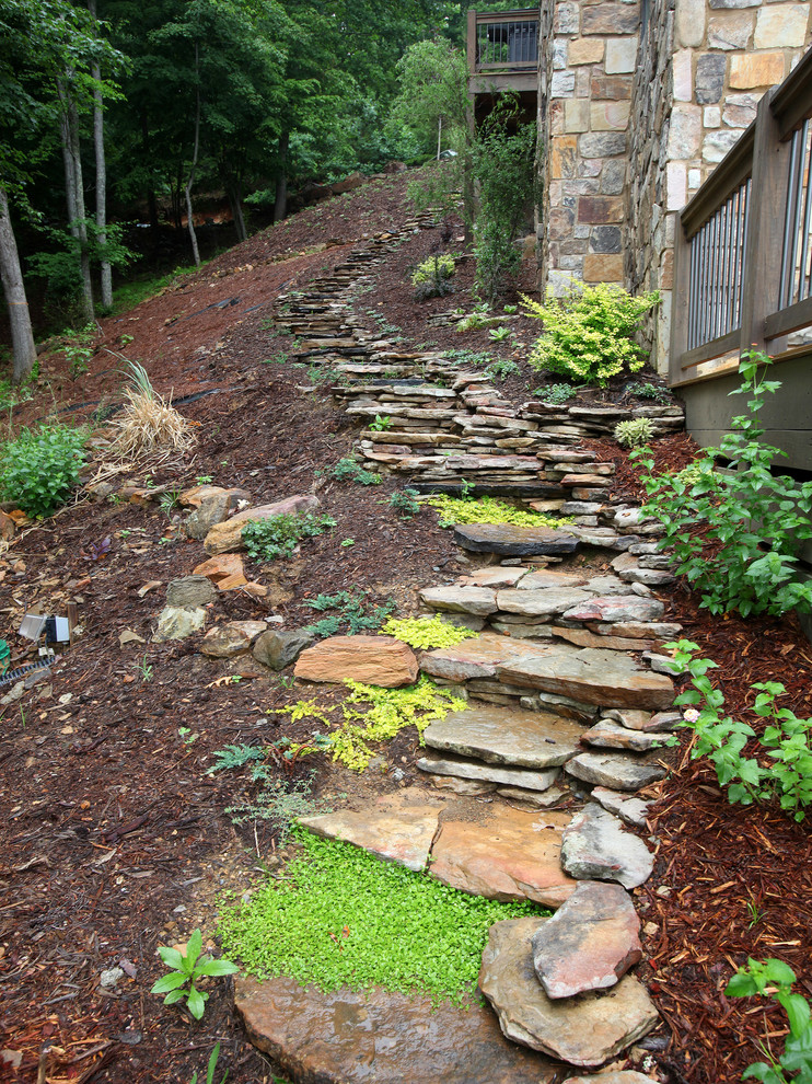 Photo of a large country side yard partial sun garden for summer in Atlanta with a garden path and natural stone pavers.