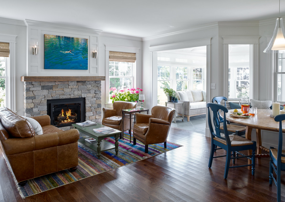 Photo of a beach style open concept living room in Portland Maine with white walls, dark hardwood floors, a standard fireplace, a stone fireplace surround and brown floor.