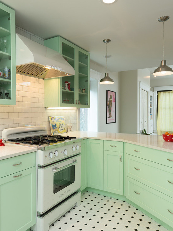 Photo of a mid-sized traditional l-shaped open plan kitchen in Chicago with a farmhouse sink, shaker cabinets, green cabinets, quartz benchtops, white splashback, subway tile splashback, white appliances, porcelain floors and a peninsula.
