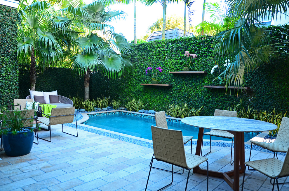 Design ideas for a mid-sized contemporary backyard rectangular pool in Miami with tile.