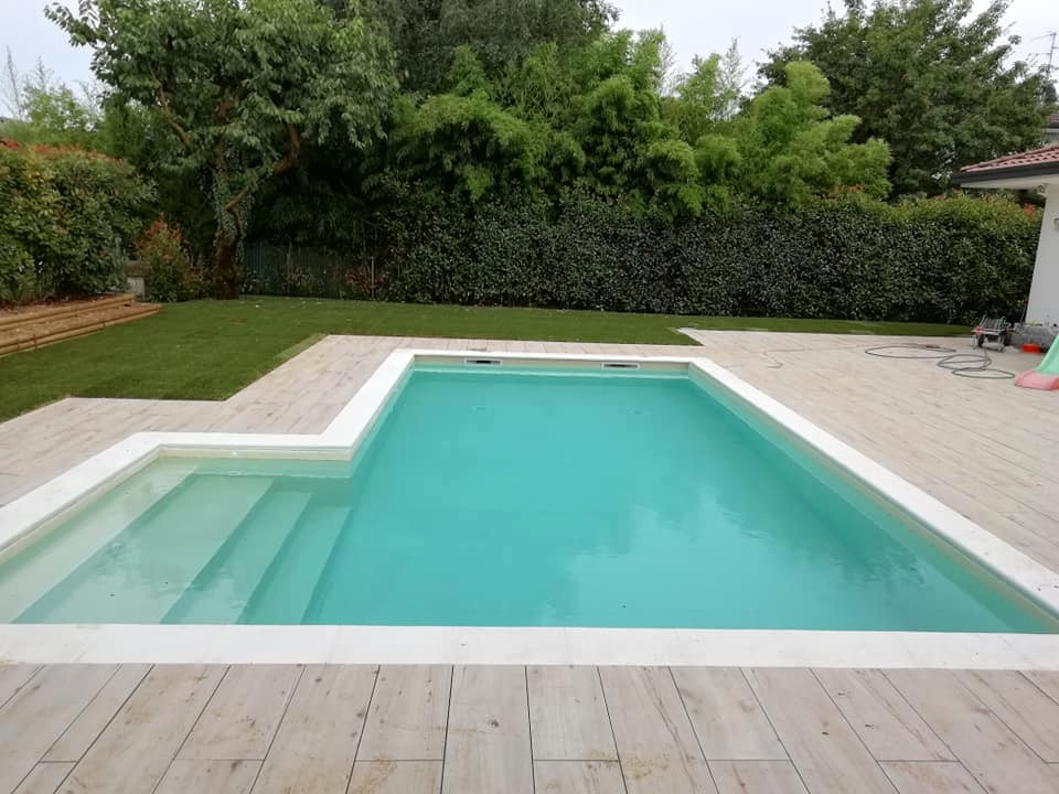 Inspiration for a mid-sized backyard l-shaped pool in Milan with with privacy feature and tile.