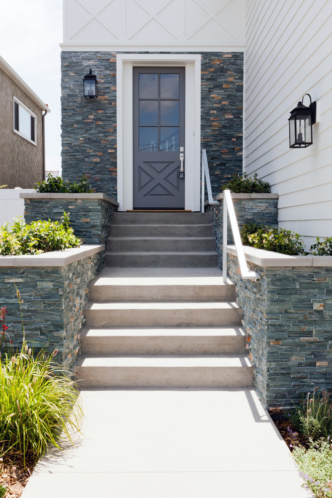 Photo of a mid-sized beach style front door in Los Angeles with a single front door and a gray front door.