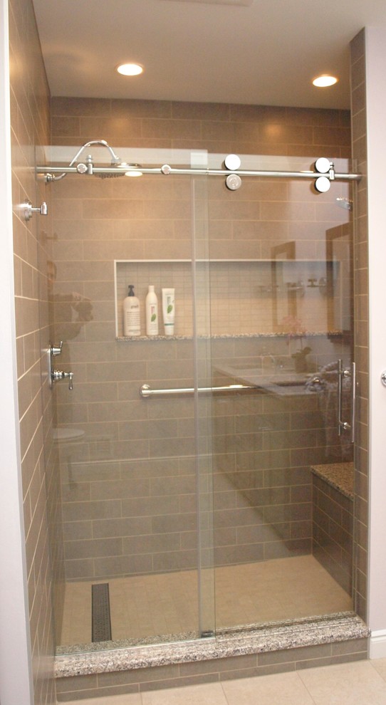 Inspiration for a large transitional master bathroom in Newark with flat-panel cabinets, brown cabinets, an alcove shower, a two-piece toilet, beige tile, ceramic tile, beige walls, porcelain floors, an undermount sink, granite benchtops, beige floor and a sliding shower screen.