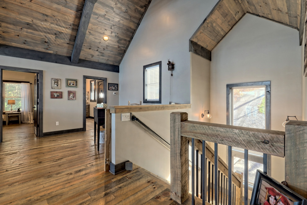 Immagine di un grande studio american style con pareti grigie, pavimento in legno massello medio, scrivania autoportante, pavimento grigio e soffitto in legno
