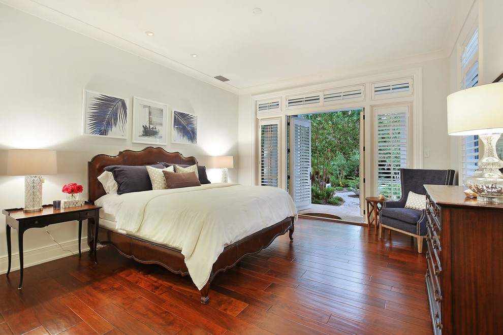 This is an example of a large tropical master bedroom in Tampa with green walls and medium hardwood floors.