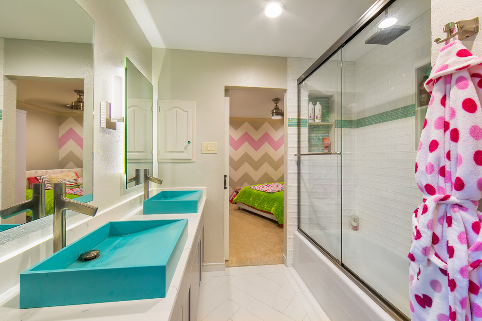 Inspiration for a mid-sized transitional kids bathroom in Dallas with an alcove tub, a shower/bathtub combo, white tile, stone slab, grey walls, porcelain floors, a vessel sink, marble benchtops, white floor, a sliding shower screen and white benchtops.