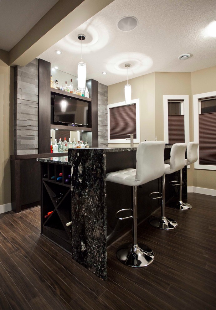 Photo of a contemporary galley home bar in Calgary with dark hardwood floors and grey splashback.