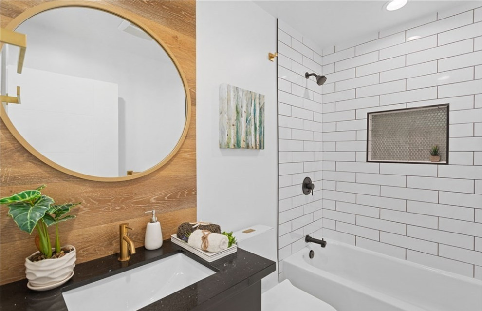 Стильный дизайн: ванная комната в современном стиле с плоскими фасадами, черными фасадами, ванной в нише, душем над ванной, унитазом-моноблоком, белой плиткой, керамической плиткой, белыми стенами, полом из керамической плитки, врезной раковиной, столешницей из кварцита, серым полом, шторкой для ванной, черной столешницей, нишей, тумбой под одну раковину и встроенной тумбой - последний тренд