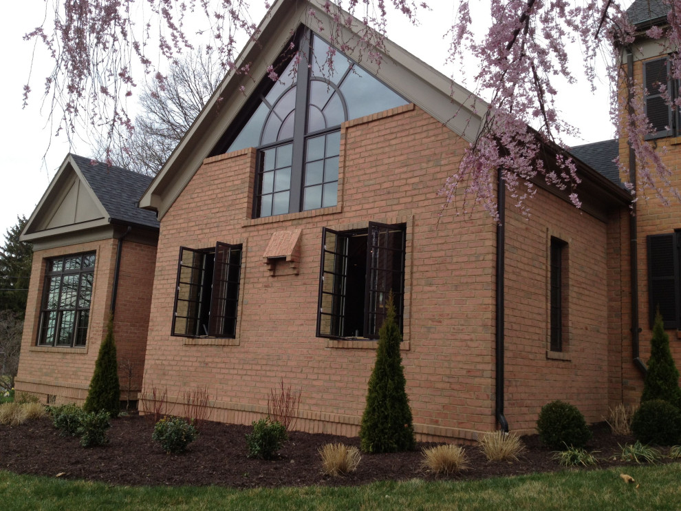 Large brown three-story brick house exterior idea with a shingle roof