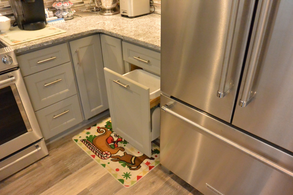 Small transitional u-shaped vinyl floor and brown floor eat-in kitchen photo in DC Metro with an undermount sink, shaker cabinets, gray cabinets, granite countertops, gray backsplash, mosaic tile backsplash, stainless steel appliances, a peninsula and gray countertops
