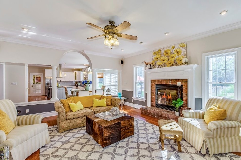 Large traditional open concept living room in Other with beige walls, medium hardwood floors, a standard fireplace, a brick fireplace surround and brown floor.