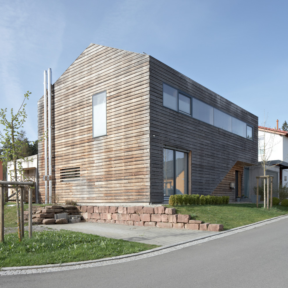 This is an example of a mid-sized contemporary two-storey brown exterior in Stuttgart with wood siding and a gable roof.