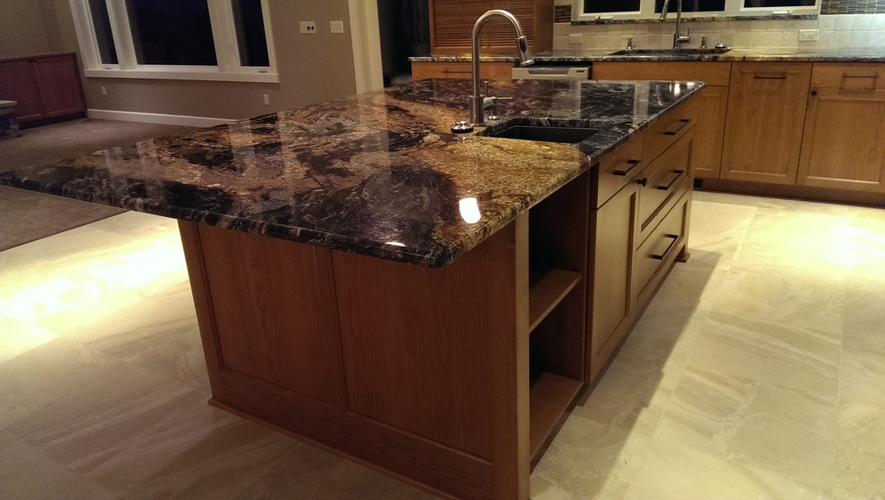 Inspiration for an arts and crafts l-shaped eat-in kitchen in Seattle with an undermount sink, recessed-panel cabinets, medium wood cabinets, granite benchtops, beige splashback, ceramic splashback and stainless steel appliances.