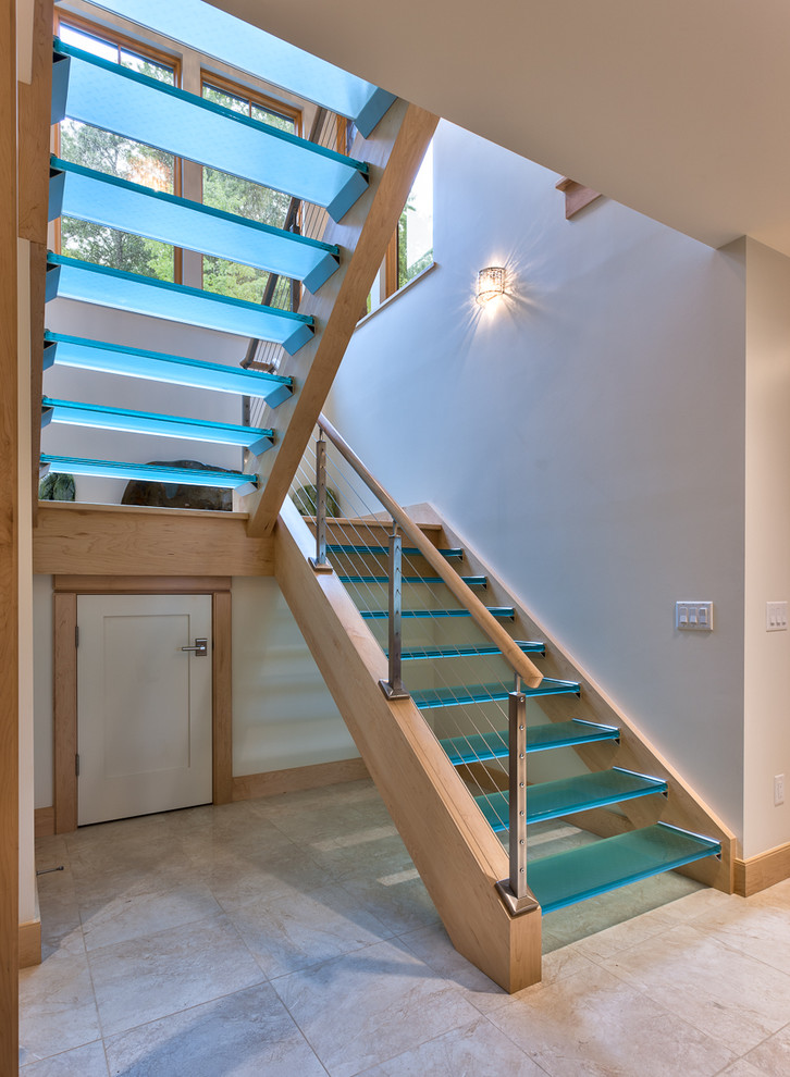 Photo of a contemporary glass staircase in Other with open risers.