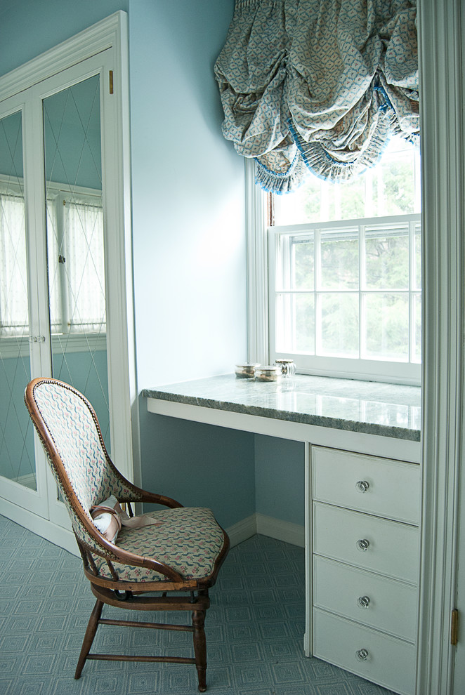Design ideas for a mid-sized traditional women's dressing room in New York with flat-panel cabinets, white cabinets, carpet and blue floor.