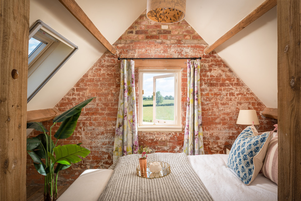 На фото: гостевая спальня среднего размера, (комната для гостей) в стиле кантри с кирпичными стенами с