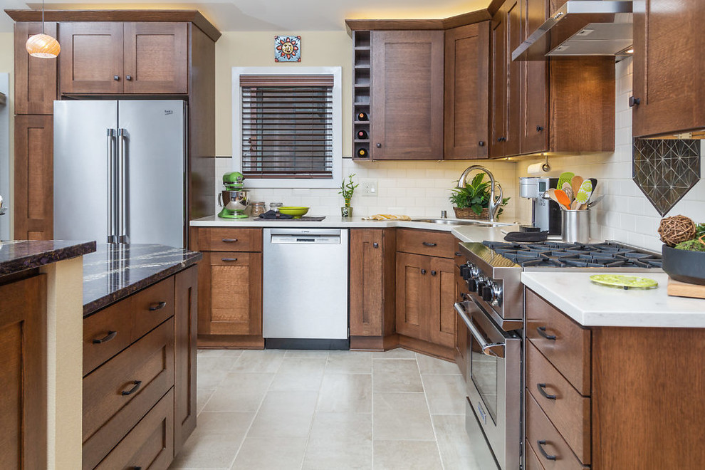 Inspiration for a mid-sized transitional l-shaped open concept kitchen remodel with recessed-panel cabinets, dark wood cabinets, quartz countertops, white backsplash, subway tile backsplash, stainless steel appliances and an island
