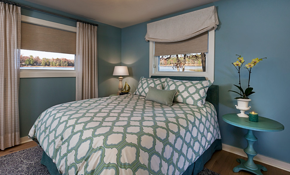 This is an example of a small beach style master bedroom in Detroit with blue walls and light hardwood floors.