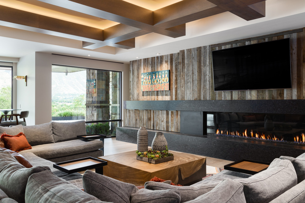Game room - huge contemporary open concept medium tone wood floor, brown floor, coffered ceiling and wood wall game room idea in Salt Lake City with beige walls, a ribbon fireplace, a wood fireplace surround and a wall-mounted tv