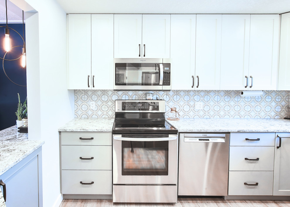 Example of a mid-sized u-shaped vinyl floor eat-in kitchen design in Edmonton with an undermount sink, flat-panel cabinets, quartzite countertops, terra-cotta backsplash, stainless steel appliances and a peninsula